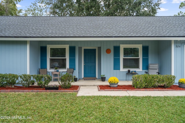 view of front of property with covered porch and a front yard