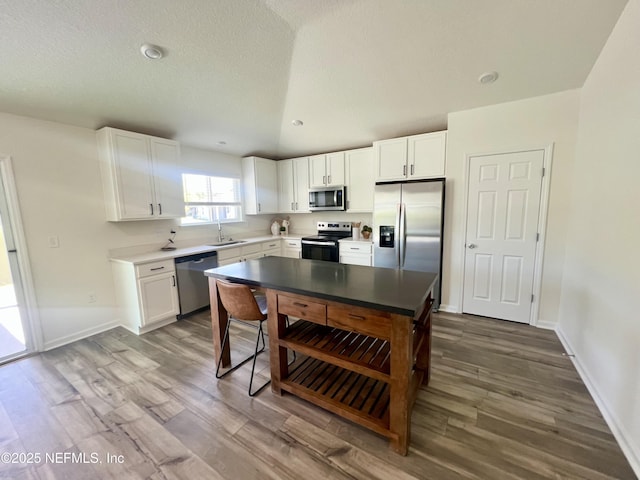 2320 Dallas Creek Ln, Green Cove Springs, FL 32043 - kitchen with stainless steel appliances, a sink, dark wood-style floors, white cabinetry, and a textured ceiling