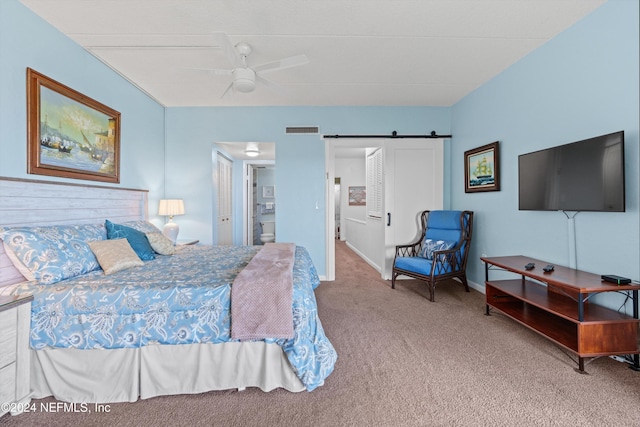 bedroom featuring a barn door, ceiling fan, and carpet floors