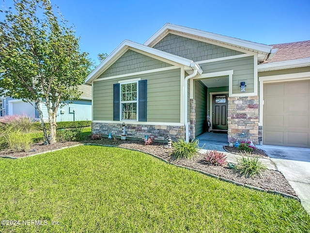 craftsman house featuring a front yard and a garage