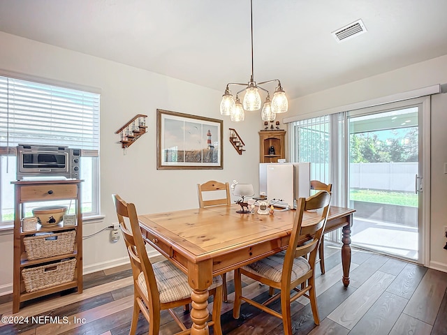 dining room featuring a notable chandelier, a wealth of natural light, and dark hardwood / wood-style floors