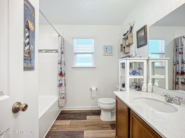 full bathroom with vanity, hardwood / wood-style floors, toilet, and shower / bathtub combination with curtain