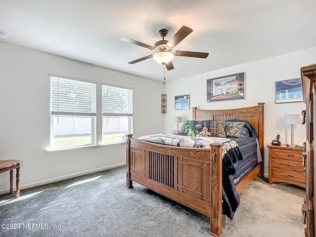 carpeted bedroom with a textured ceiling and ceiling fan