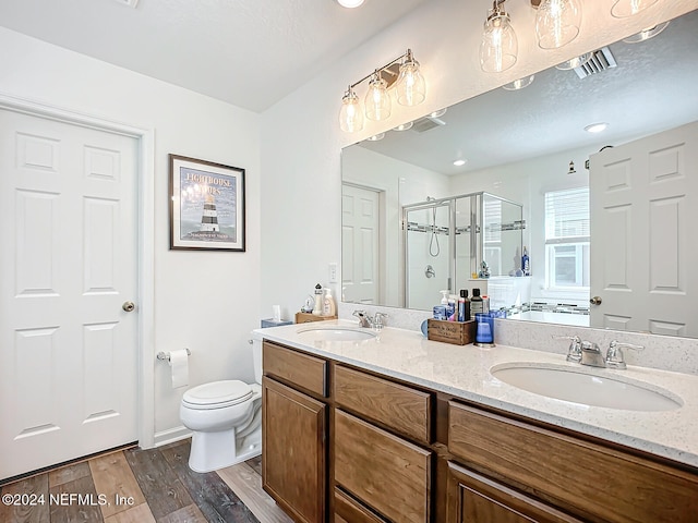 bathroom featuring vanity, hardwood / wood-style floors, walk in shower, and toilet