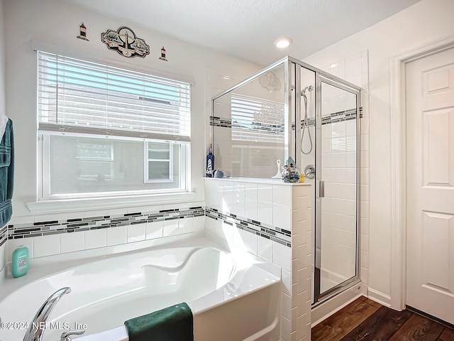 bathroom with independent shower and bath and wood-type flooring