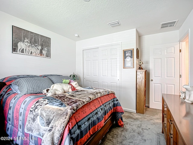 carpeted bedroom with a closet and a textured ceiling