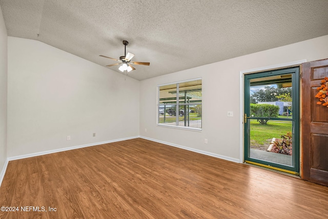 spare room featuring a textured ceiling, hardwood / wood-style flooring, ceiling fan, and vaulted ceiling