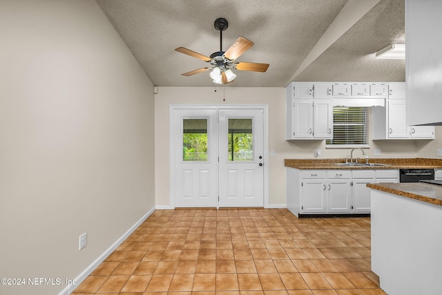 kitchen featuring sink, dishwasher, a textured ceiling, white cabinetry, and ceiling fan