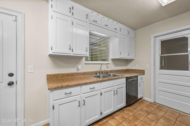 kitchen with black dishwasher, light tile patterned flooring, sink, a textured ceiling, and white cabinets