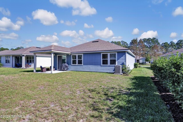 647 La Mancha Dr, Saint Augustine, FL 32086 - rear view of property featuring cooling unit, a patio area, a yard, and roof with shingles