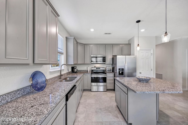 647 La Mancha Dr, Saint Augustine, FL 32086 - kitchen with gray cabinetry, stainless steel appliances, a sink, light stone countertops, and recessed lighting