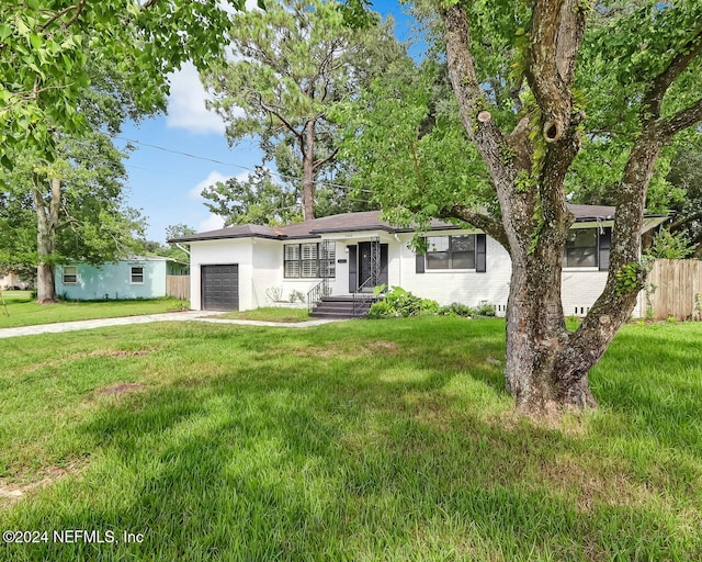 single story home featuring a front lawn and a garage