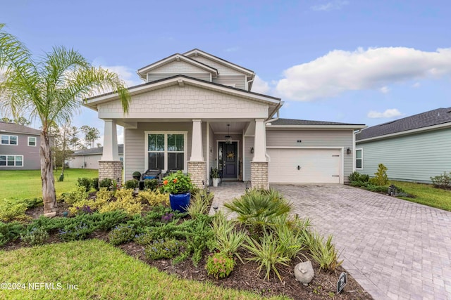 craftsman-style home with a front lawn, covered porch, and a garage