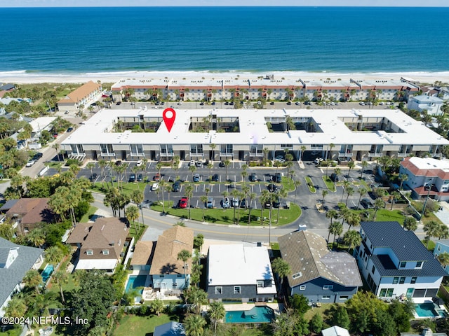 birds eye view of property with a water view and a beach view