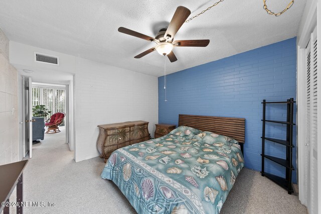 bedroom with ceiling fan, a textured ceiling, and light colored carpet