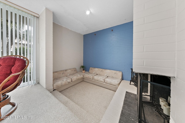 living room featuring carpet floors and a brick fireplace