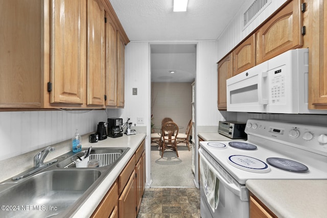 kitchen with a textured ceiling, sink, and white appliances