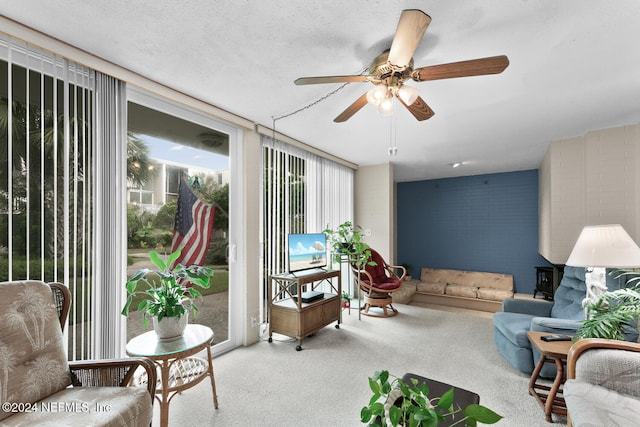 carpeted living room with ceiling fan and a textured ceiling