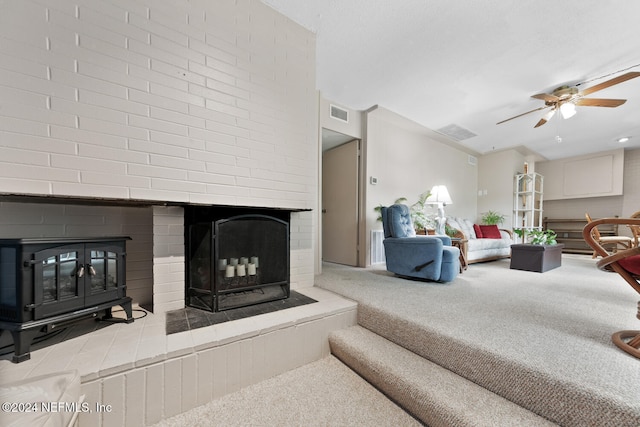 living room with a fireplace, carpet flooring, and ceiling fan