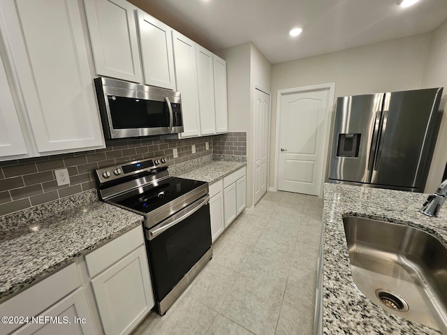 kitchen with white cabinets, sink, appliances with stainless steel finishes, and tasteful backsplash