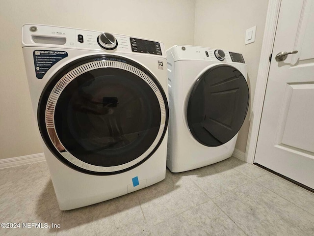 clothes washing area with separate washer and dryer and light tile patterned floors