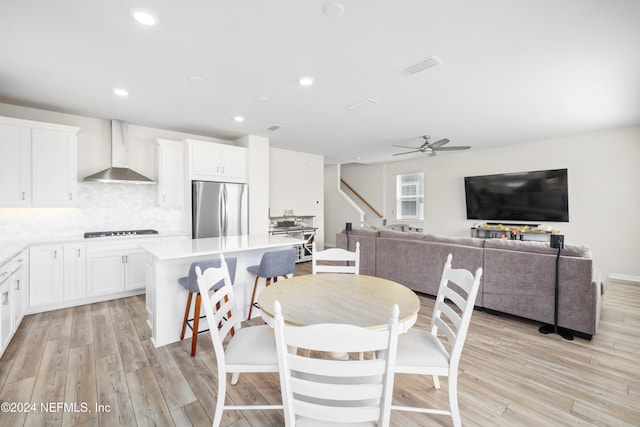 dining space featuring light wood-type flooring and ceiling fan