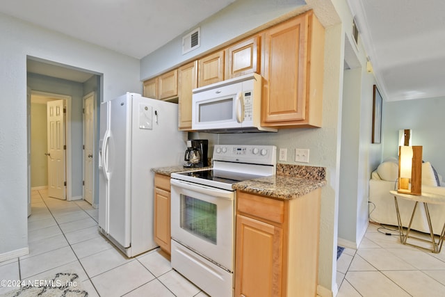 kitchen featuring white appliances, light stone counters, light tile patterned floors, and light brown cabinets