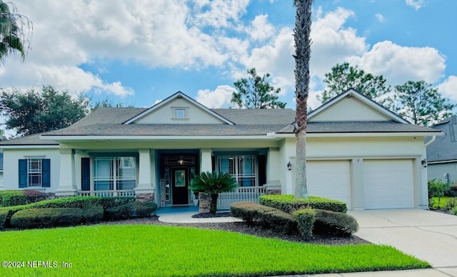 view of front facade with a porch, a front yard, and a garage