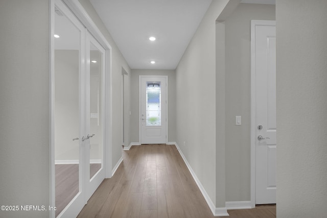 entryway with wood finished floors, baseboards, and french doors