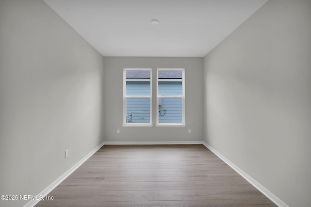 unfurnished room featuring baseboards and wood finished floors