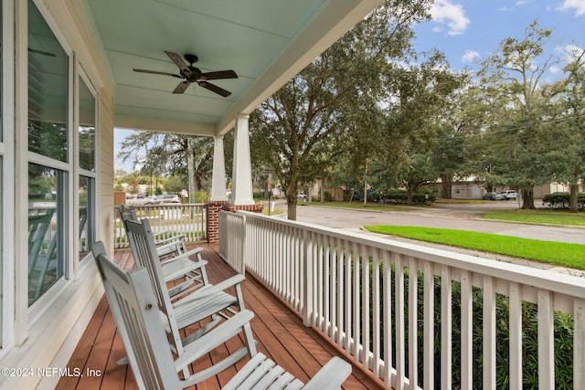 wooden terrace with ceiling fan and covered porch