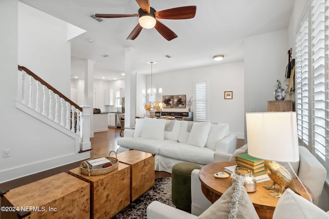 living room featuring hardwood / wood-style flooring and ceiling fan with notable chandelier