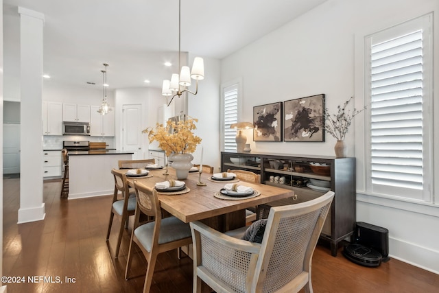 dining room with dark hardwood / wood-style floors and an inviting chandelier