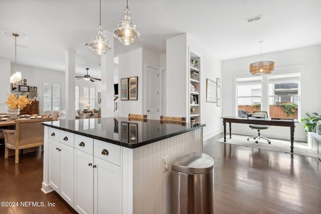 kitchen with dark hardwood / wood-style floors, white cabinetry, decorative light fixtures, and a kitchen island