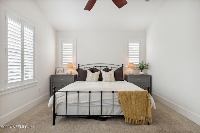 carpeted bedroom featuring multiple windows and ceiling fan