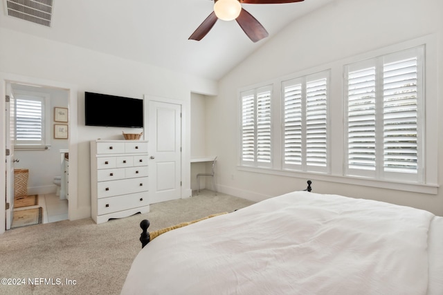 bedroom featuring ensuite bath, lofted ceiling, ceiling fan, and light carpet