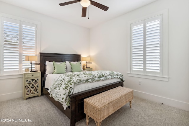 bedroom with multiple windows, light colored carpet, and ceiling fan