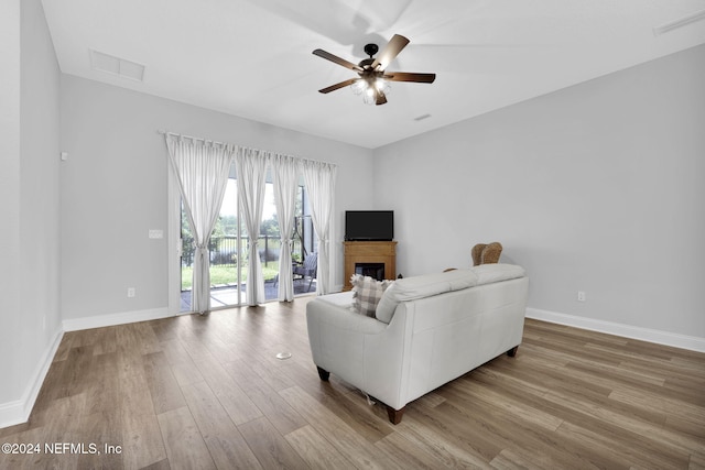 living room featuring light hardwood / wood-style floors and ceiling fan