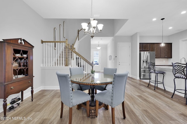 dining room with light hardwood / wood-style flooring and a chandelier