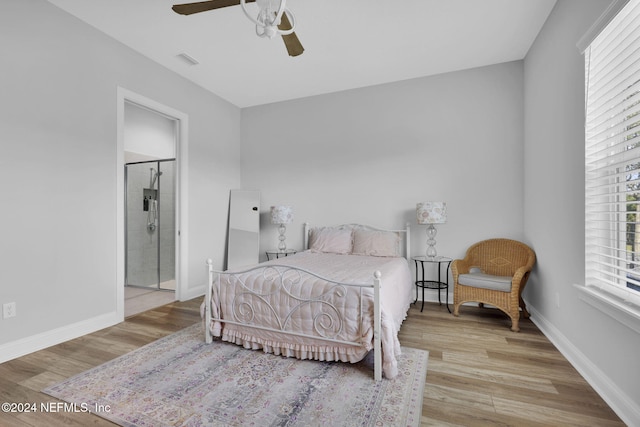 bedroom featuring ceiling fan, light wood-type flooring, and ensuite bath