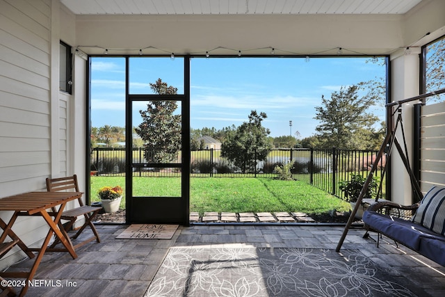 unfurnished sunroom featuring beamed ceiling