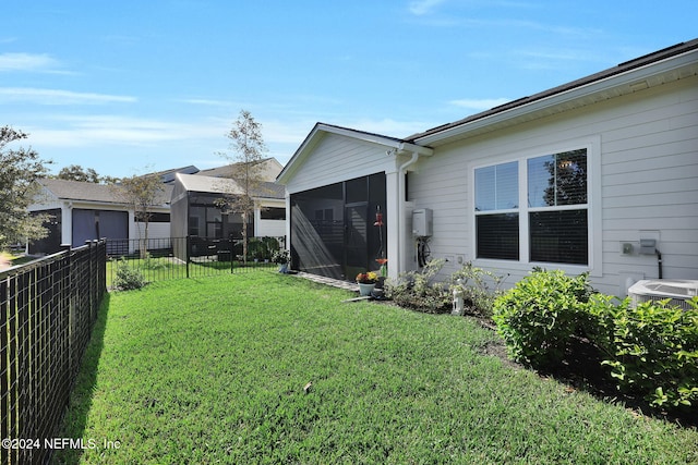 view of yard with central AC unit and a sunroom