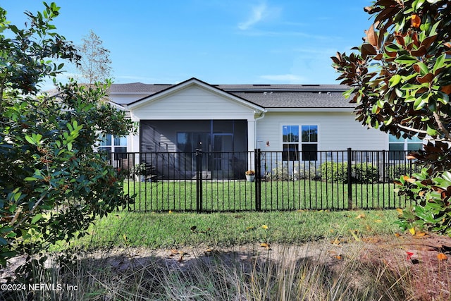 view of front of house featuring a sunroom and a front lawn