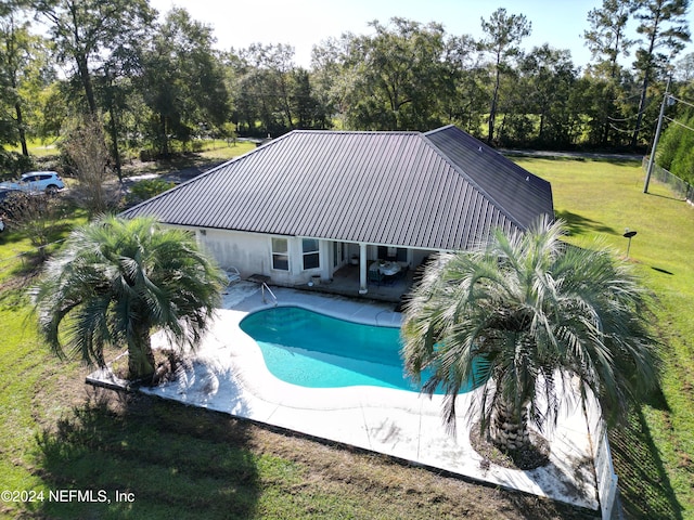 view of swimming pool featuring a patio and a lawn