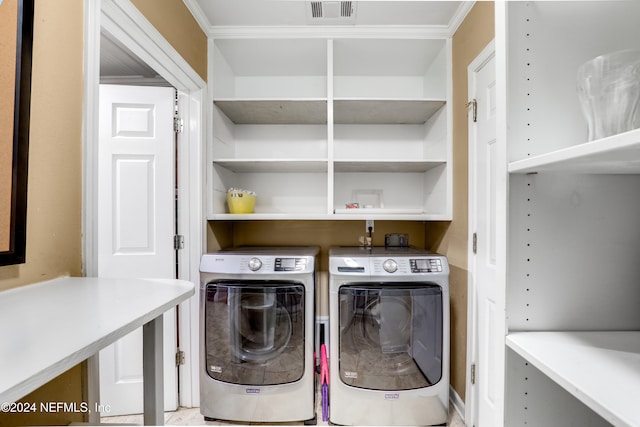 laundry room with crown molding and washing machine and dryer