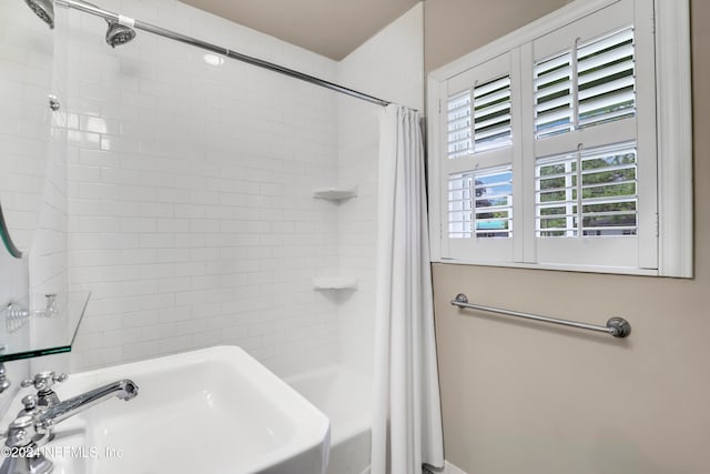 bathroom with shower / bath combo with shower curtain and sink