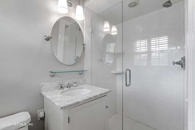 bathroom with toilet, a shower with shower door, and vanity