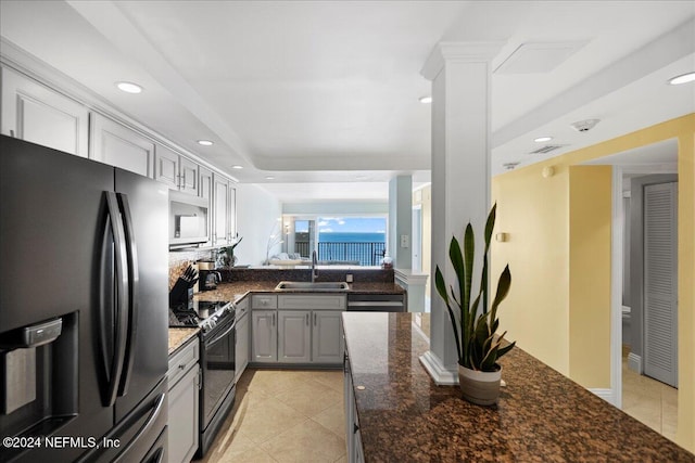 kitchen with light tile patterned flooring, dark stone counters, appliances with stainless steel finishes, gray cabinets, and sink