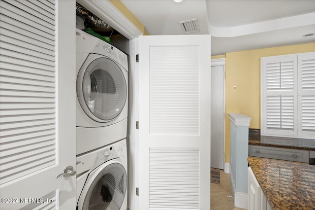 clothes washing area featuring stacked washer and dryer