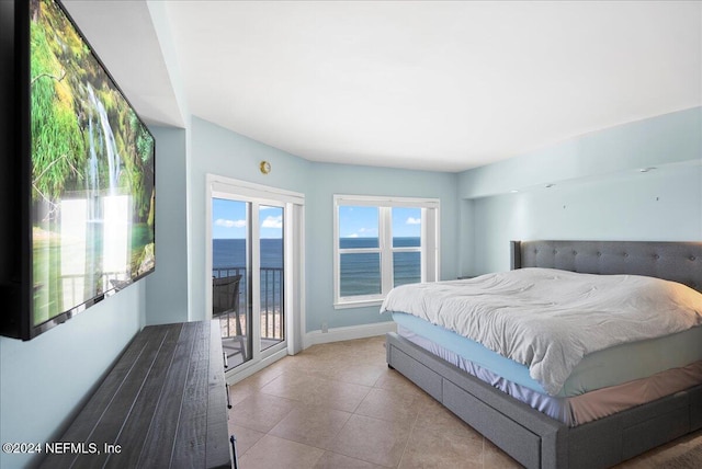 bedroom with access to exterior, a water view, and light tile patterned floors